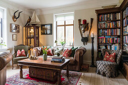 Antique bookcase, leather couch and hunting trophies in the living room