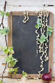 Branch with hydrangea blossoms and pearl necklaces on a chalkboard