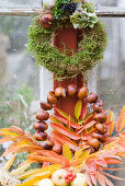 Herbstkränze aus Moos und Kastanien mit buntem Herbstlaub, Hortensienblüte, Buchs und Ligusterbeeren