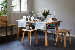 Gedeckter Tisch im Skandinavischen Stil mit Stühlen und Hockern