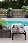 Lounger with floral towel next to coffee table by the pool