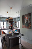 Konsolentisch und Mittelblock in offener Küche mit Gemälde an der Wand