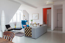 Sofa und Sessel in offenem Wohnraum mit grau lackierten Dielen