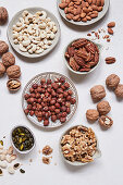 Assorted shelled nuts in bowls and plates
