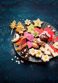 Assorted colourful Christmas biscuits on plates