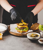 Essiggurken auf Cheeseburger anrichten