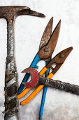 Hammer, tin snips and wrench on metal surface