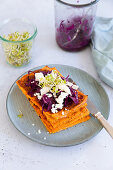 Carrot flatbread with red cabbage salad, feta and radish sprouts