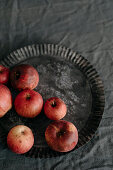 Fresh organic red apples in a vintage tart pan