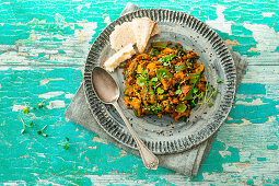 Vegan curry dish with lentils, zucchini, sugar snap peas and spinach