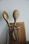 Wooden salad servers and herb scissors in a measuring cup
