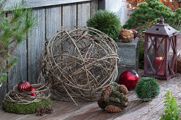 Ball of clematis vines with Christmas tree ornaments, moss wreath, and lantern