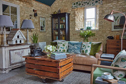 DIY coffee table made from reclaimed wood on castors in living room with stone walls