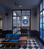 Wooden sofa with blue upholstery on chequered floor in period building