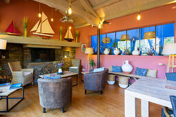 Lounge with colorful walls, natural stone fireplace and model sailboats