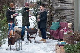 Friends standing comfortably around the firepit