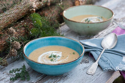 Potato soup with herbs and cream in soup bowls