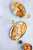 Zwei Grillplatten mit Fisch, Garnelen, Calamari, Pommes und Reis