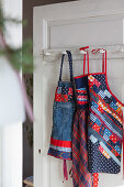Patchwork aprons hung on a door