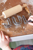 Children's hands-on wooden board with gingerbread dough, cookie cutters, and rolling pin