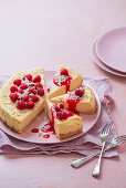 American baked cheesecake with fresh raspberries and raspberry sauce