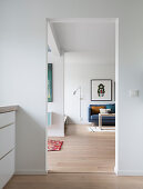 Open doorway leading into living room with blue couch, lamp and picture on wall