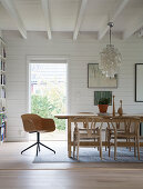 Dining table in room with white-painted wood cladding