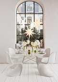 Weihnachtlich gedeckter Tisch mit Amaryllis und weiße Klassikerstühle