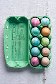Colorful dyed Easter eggs in pastel colors in an egg carton