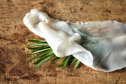 A thin slice of lardo with rosemary