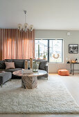 Grey upholstered sofa and round marble table in the living room