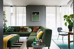 Green corner sectional sofa with cushions in an open plan living space