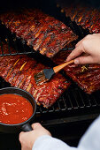 Brushing Saint Louis Style spare ribs with marinade