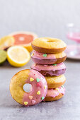 Mandel-Donuts mit Blutorangenglasur und herzförmigen Zuckerstreuseln