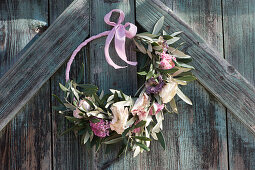 Door wreath with ranunculus blossoms and olive branches