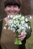 Woman holding a bouquet of snowdrops in her hand