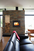Black leather couch in front of fireplace