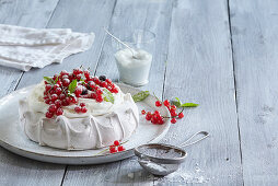 Baiserkuchen mit Schlagsahne und roten Johannisbeeren