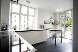 Weiße Schränke in Küche mit Betonboden