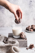 Glutenfreie Schokoladen-Crackle-Cookies in Milch tauchen
