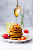 Sweet potato pancakes with crunchy muesli, honey and strawberries (gluten-free)