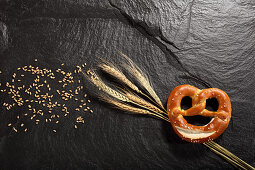 Pretzel next to cereal ears and cereal grains