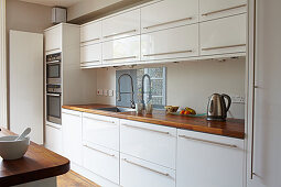 White fitted kitchen with wooden worksurface