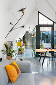 Grey sofa with scatter cushion and dining area in the background in loft apartment