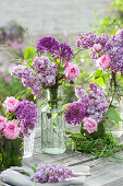 Spring bouquets of lilacs, roses, and allium with grass and a grass wreath