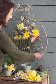 Woman creates hanging Easter decoration on the terrace