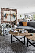 Coffee table, sofa and armchair in front of brick wall in living room