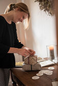 Woman attaching DIY tag to Christmas gift