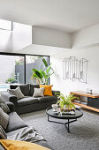 Grey sofa set, coffee table and lowboard in light-flooded seating area