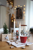 A Christmas dining table with a nutcracker, candles and cinnamon stars